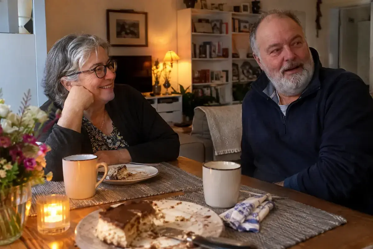 Una pareja mayor comparte una comida de aniversario en casa.