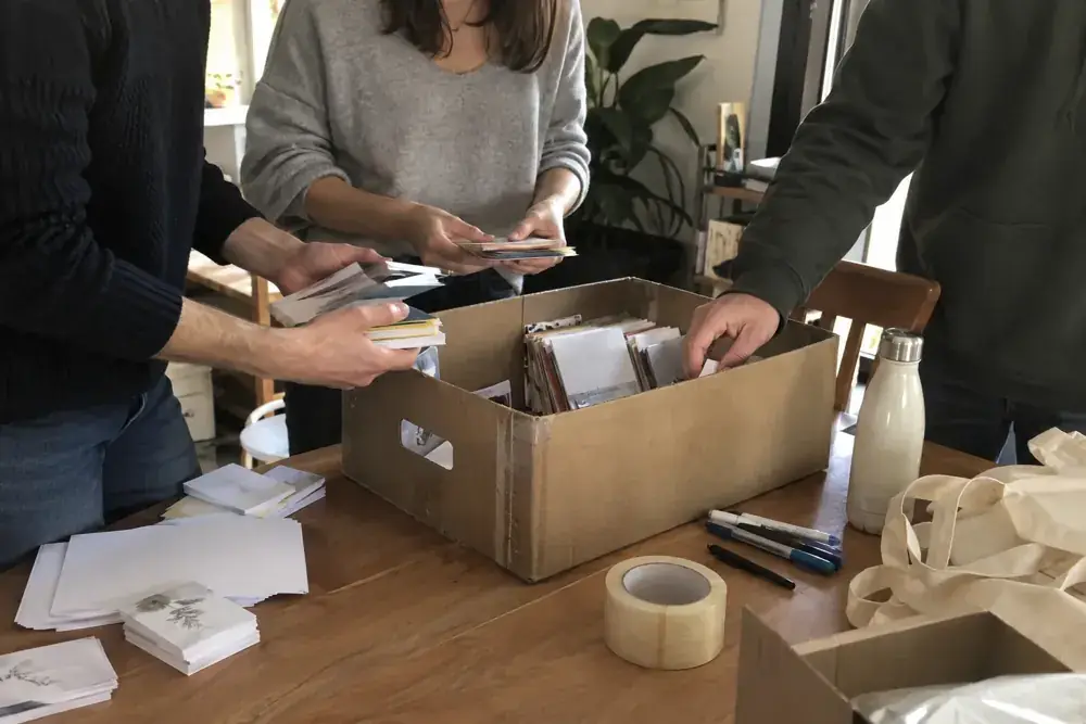 Imagen generada: Manos organizando tarjetas sin datos en una caja de cartón reutilizada.