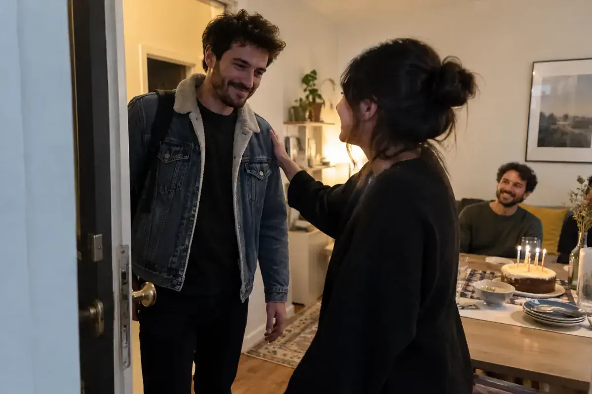 Un amigo recibe al festejado en la entrada de una reunión sorpresa.
