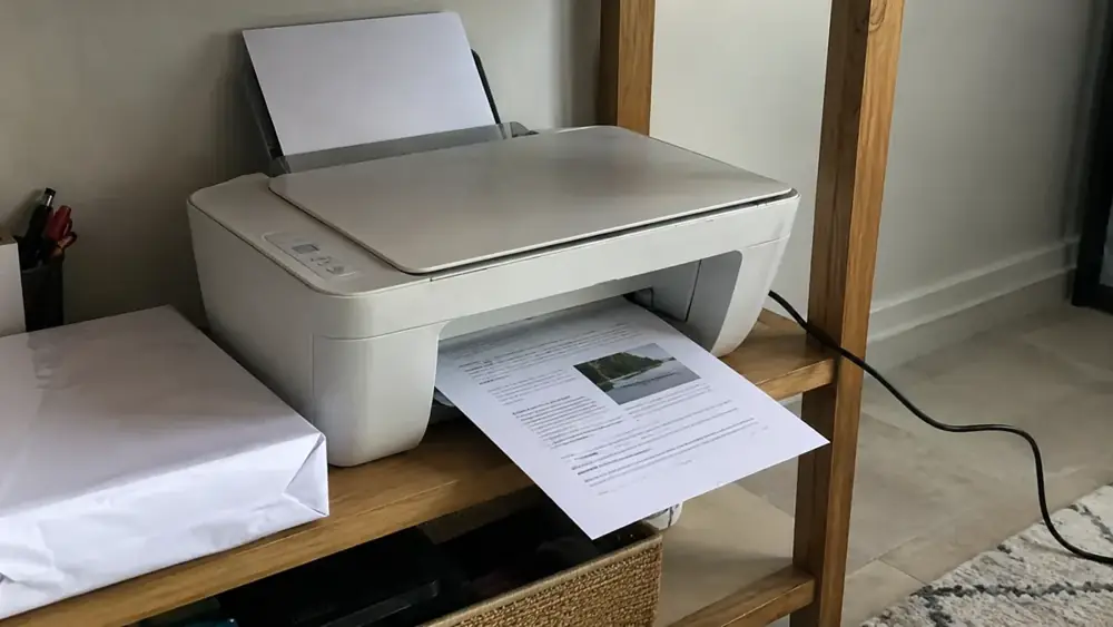 Imagen generada: Impresora doméstica con una hoja de papel junto a sobres.
