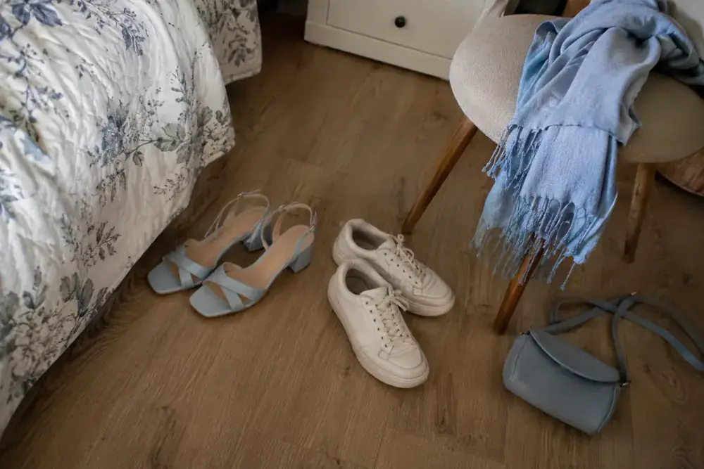 Zapatos de celebración y tenis cómodos junto a un chal y una bolsa.