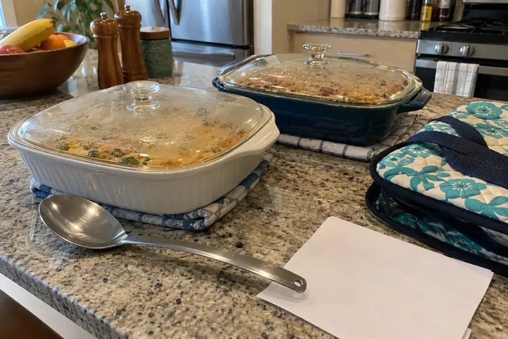 Fuentes tapadas y utensilios listos para llevar a una comida familiar.